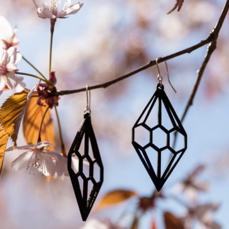 black wooden diamond earrings hanging on cherry branches
