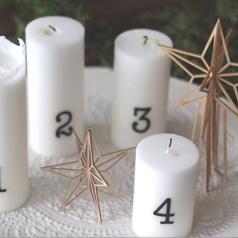 Advent candles and wooden star and christmas tree topper on a plate