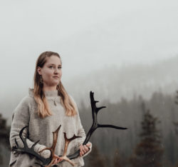 Woman standing in nature with antlers