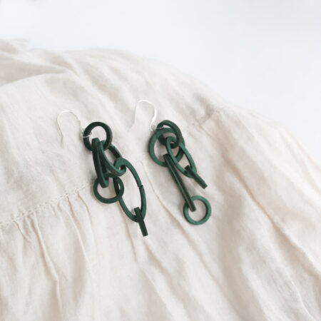 Wooden green colour chain jewellery earrings on white cloth