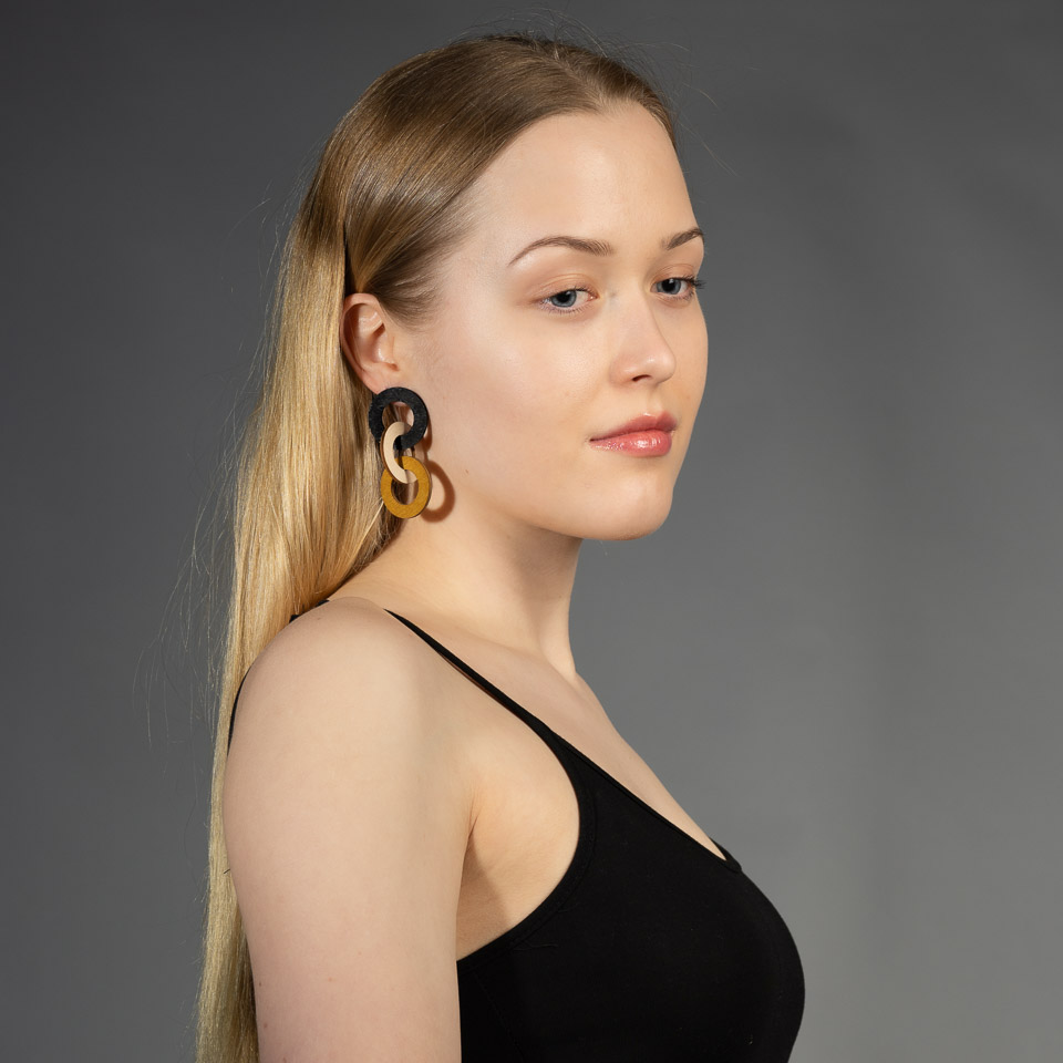 Woman wearing wooden statement chain earrings