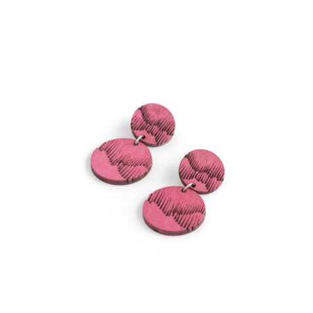 Vaaleanpunaiset revontuli korvakorut valkoisella pöydällä