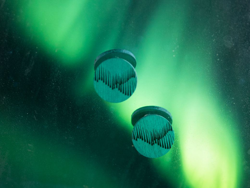 Northern lights jewellery with green aurora borealis backround