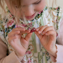 Little girl looking at wooden heart pendant