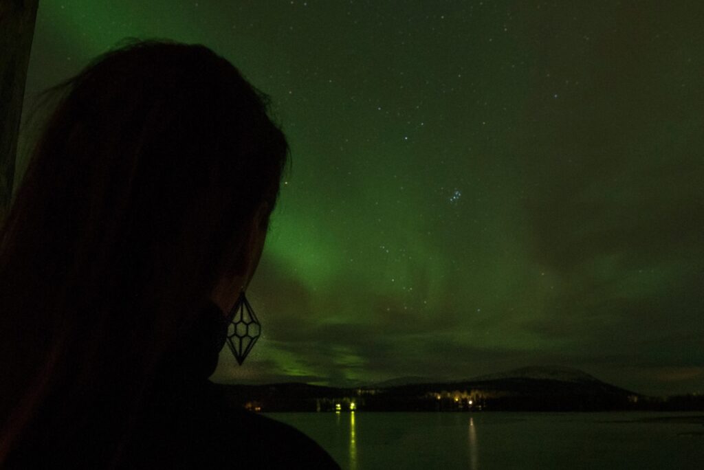 Silhouette of a woman standing under Northern Lights