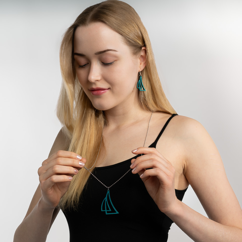 Woman holding sailboat jewelry