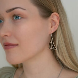 Lähikuva naisen kasvoista ja korvasta jossa purjekoru