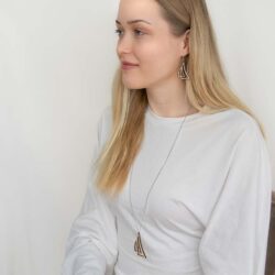 Nainen vaaleassa vaatteessa purjekorut yllään