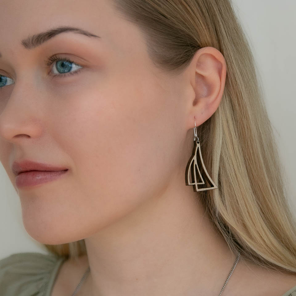 Lähikuva naisen kasvoista ja korvasta jossa purjekoru