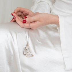 Nainen pitää kädessään purje-kaulakorua