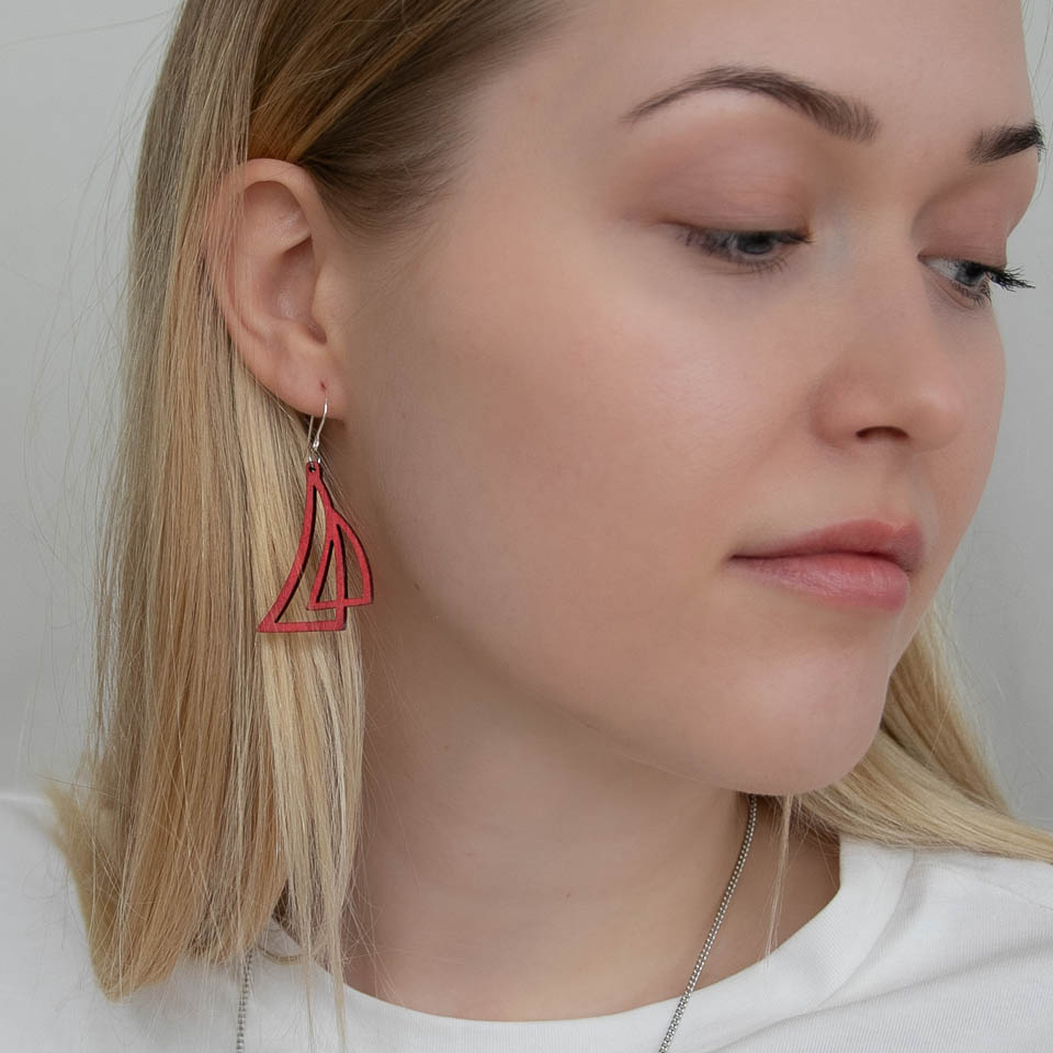 Nainen, jolla on punainen purjekorvakoru