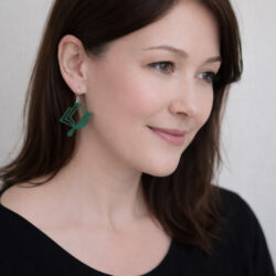 Woman wearing green book bird earrings