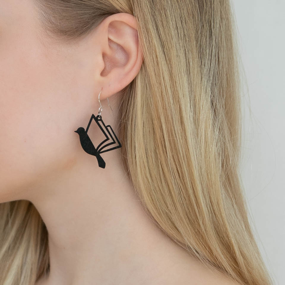 Naisen korva ja musta kirjalintu-korvakoru
