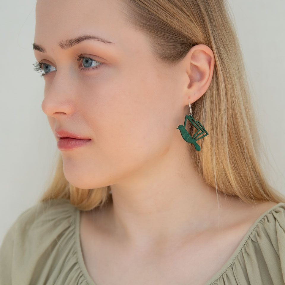 Vihreät lintukorvakorut naisella