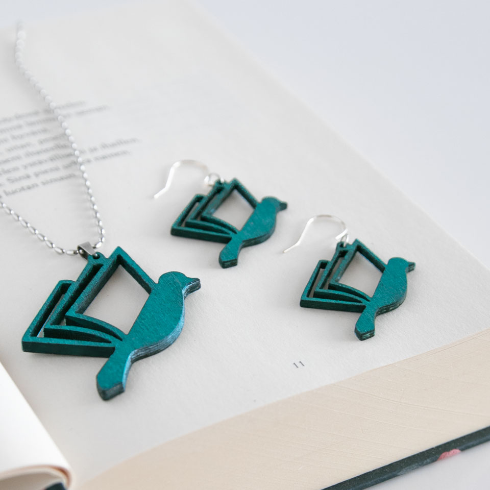 Turkoosi kirjalintu -korusetti kirjan päällä