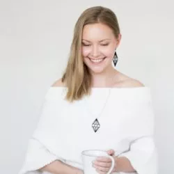 blond woman wearing wooden black diamong earrings and pendat