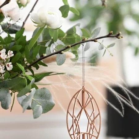 Wooden Easter egg hanging from a flower bouquet