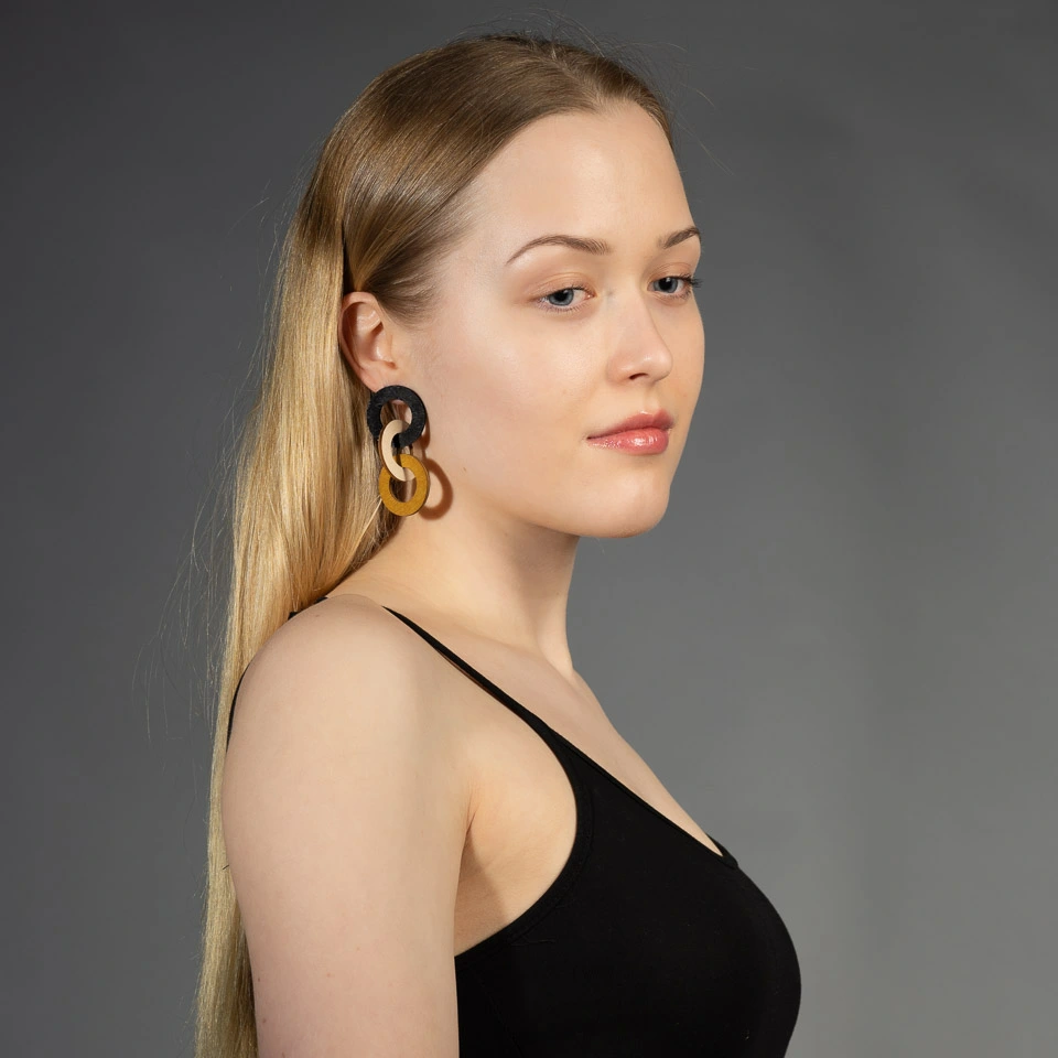 Woman wearing wooden statement chain earrings