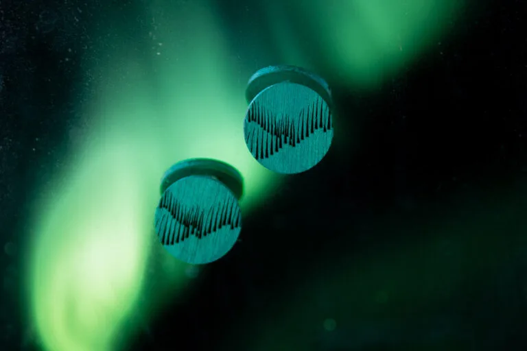 Wooden Valona Northern Lights earrings against the night sky