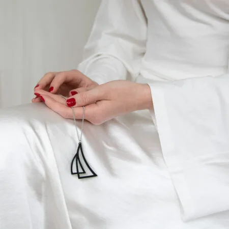 Musta purjekoru ja naisen kädet