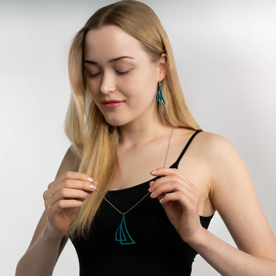 Woman holding sailboat jewelry