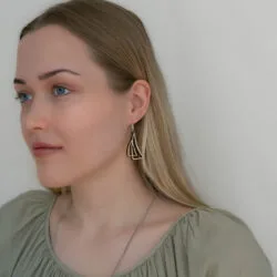 puoliprofiili naisesta, jolla purjekorvakorut