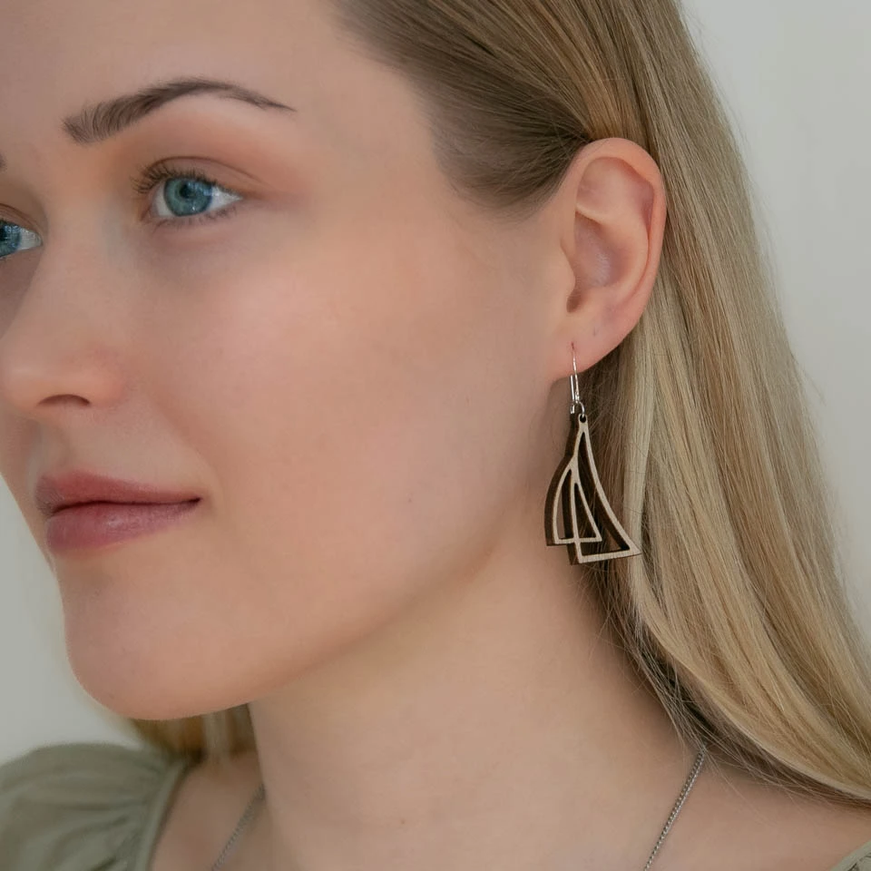 Lähikuva naisen kasvoista ja korvasta jossa purjekoru