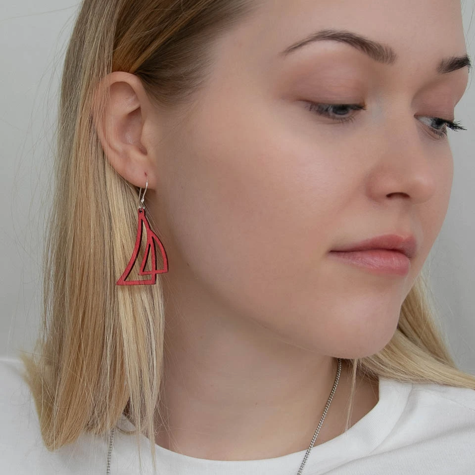 Nainen, jolla on punainen purjekorvakoru