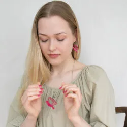 Nainen pitelee kirjalintu korua kädessään